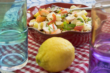 sea salad in a red tureen with a lemon