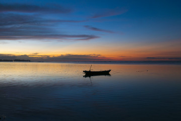 Sunset with fisher boat and still water on Gili Air Island, Indo