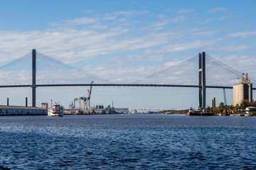 River Boat Under Suspension Bridge