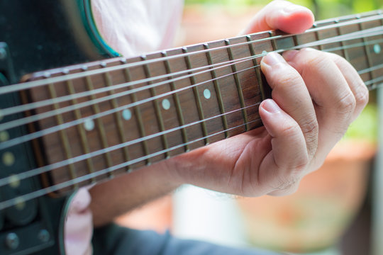 Guitarist playing an electric guitar. Shallow depth of field.