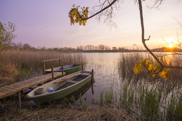 wschód słońca nad jeziorem,łódki przy pomoście