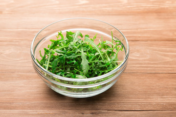 Fresh green arugula leaves in a glass bowl