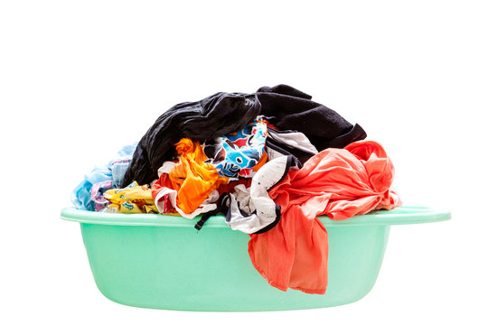 Pile of dirty laundry in a washing basket on white background.