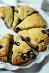 Blueberry scones cut in triangles on white plate 