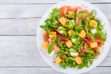 Arugula, prosciutto, mozzarella and melon salad, top view