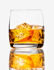 Glass of scotch whiskey and ice on a white background, isolated