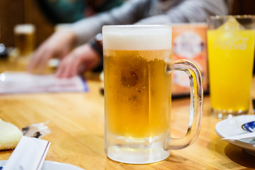 Glass of light beer on table