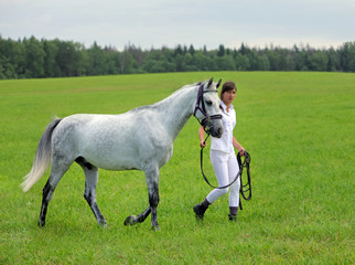 Obraz premium Female rider walking with horse 
