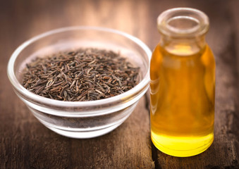 Caraway seeds with essential oil in glass bottle