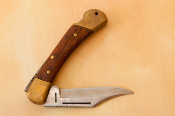 Vintage pocket knife with wooden handle and brass fixings.
Close up, still life image of an open pocket knife.