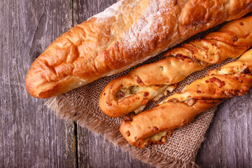 Assortment of fresh baked bread on burlap on rustic table