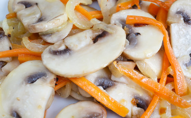 Roasted mushrooms with onion, carrot and two pancake filled with cheese  closeup