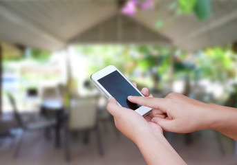 hand hold and touch screen smart phone, on blurred photo of coff