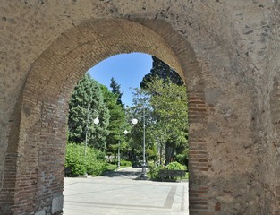 Old stone arch to a green park in Sicily