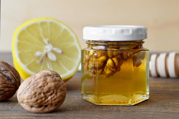 Honey, lemon and walnuts on wooden background