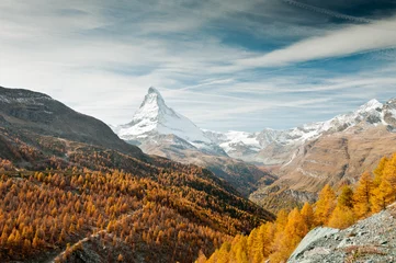 Foto auf Acrylglas Matterhorn Blick auf Herbstwald, schneebedecktes Matterhorn, Berge und blauer Himmel mit weißen Wolken, Schweiz