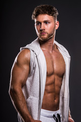 Portrait of handsome young bodybuilder , on grey