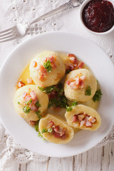 Potato dumplings stuffed with ham, bacon and onion close-up. vertical top view
