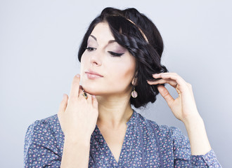 Beautiful brunette on a gray background.Eyelash extensions. Lip augmentation. nail extension
