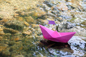 Papierschiff schwimmt im Bach