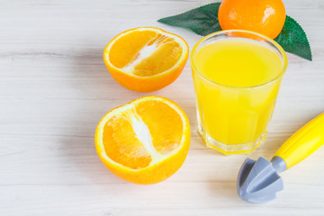 Orange juice in glass, fresh fruits on wooden background