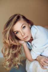 Fototapeta premium Beautiful young sexy girl in a sweater on the bed