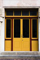 Red framed glass and yellow wooden doors