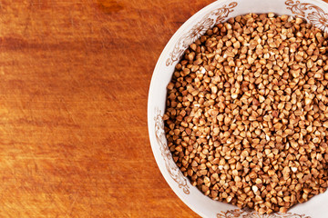 Buckwheat groats in a bowl on a wooden background