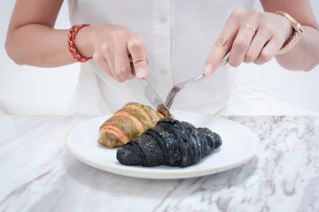 Asian woman eating Charcoal and green tea croissants