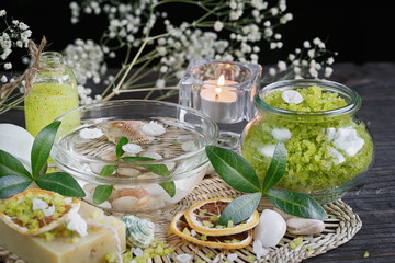 Composition of spa treatment with green salt and soap on wooden
