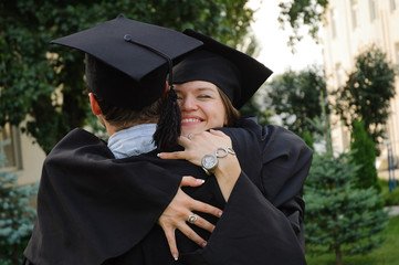 A graduates in the mantle embrace and enjoy. Beautiful graduate girl and boy enjoyed the ceremony...