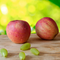 Closed up new and fresh apple and grapes on wood background
