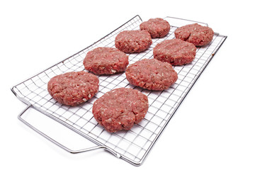 minced meat arranged over metallic grill.