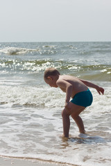 the little boy frolics at the sea