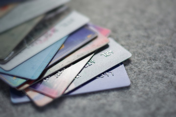 Colorful stack of credit cards and shopping gift cards on gray c