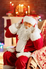 Santa Claus sitting with headphones sitting in comfortable rocking chair at home