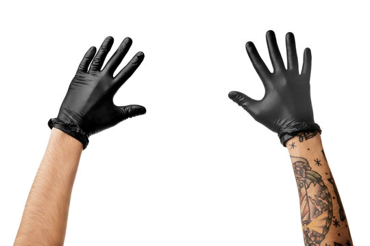 Naklejki Man's hands with tattoo in black latex gloves