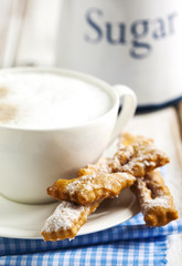 Cup of cappuccino and deep-fried pastry