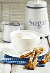 Cup of cappuccino and deep-fried pastry