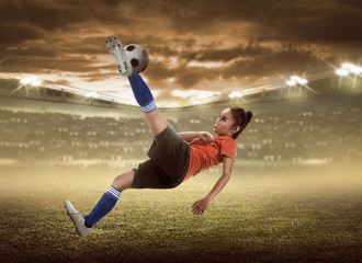 Asian woman football player kick ball