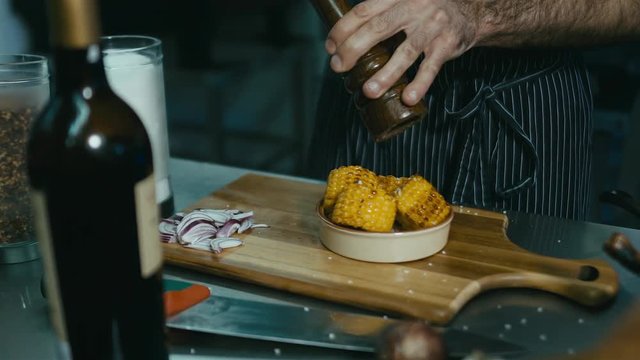 Chef sprinkling corn with pepper. 60 FPS slow motion shot. Blackmagic URSA Mini
