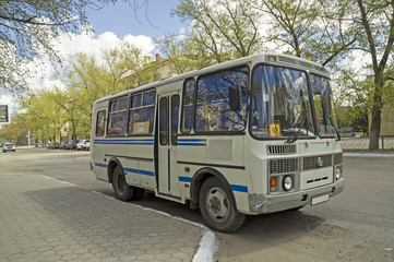 Fototapeta na wymiar Маленький автобус со знаком дети стоит у тротуара