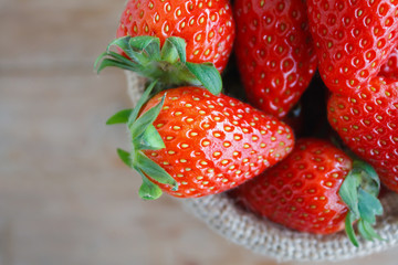 strawberries in small sack on wooden table background