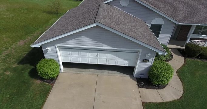 A high angle view of a vehicle pulling out of a garage.  	