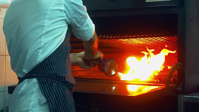 Restaurant chef kindles coals with a burner. 120 FPS slow motion shot. Blackmagic URSA Mini