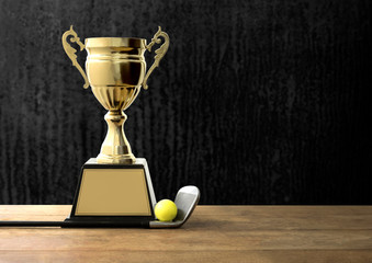 champion golden trophy on wood table with Golf clubs and golf ba