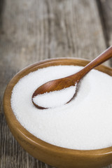 Sugar and wooden spoon in a bowl