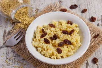 Cooked millet groats on white plate, healthy food and nutrition