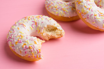 Donut with sprinkles on the pink background