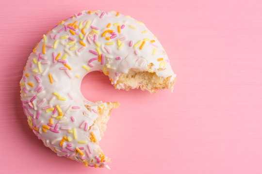 Donut with sprinkles on the pink background